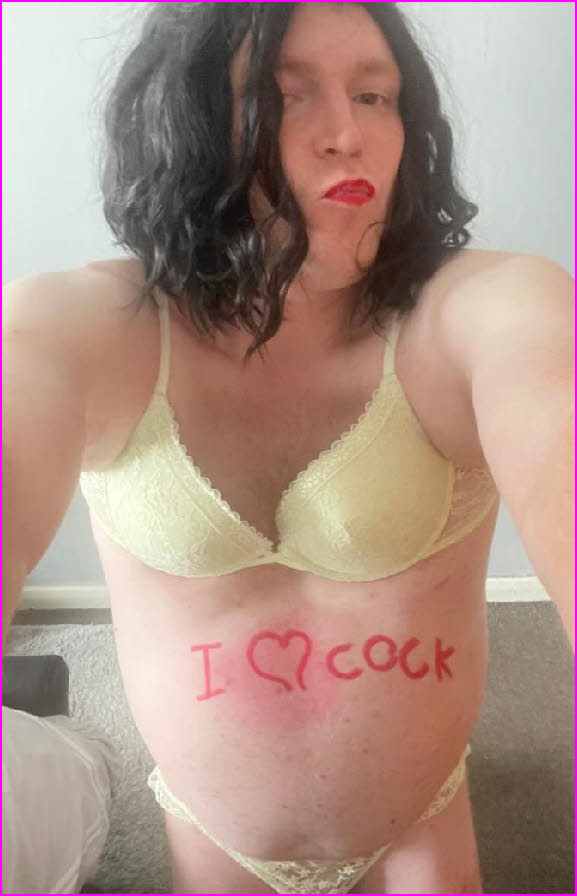 Sissy Madison with 'I love cock' scrawled on his flesh in red lipstick