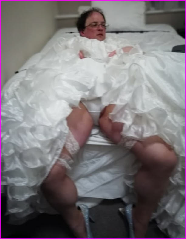 Loser male cross-dressing in a wedding dress shows off his white knickers